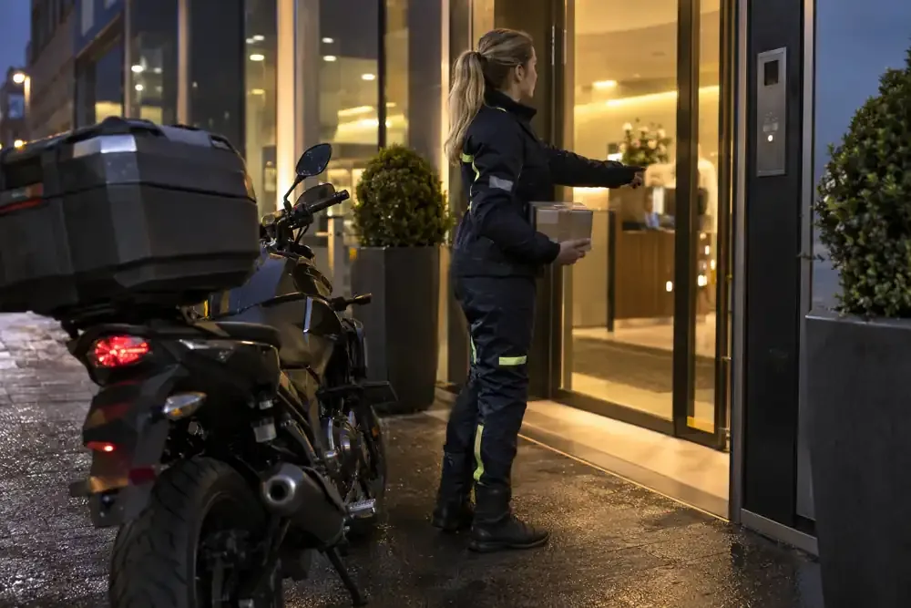 a motorcycle courier preparing or handing over a suitable consignment